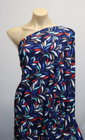 Mannequin wearing a colorful patterned dress against a plain background