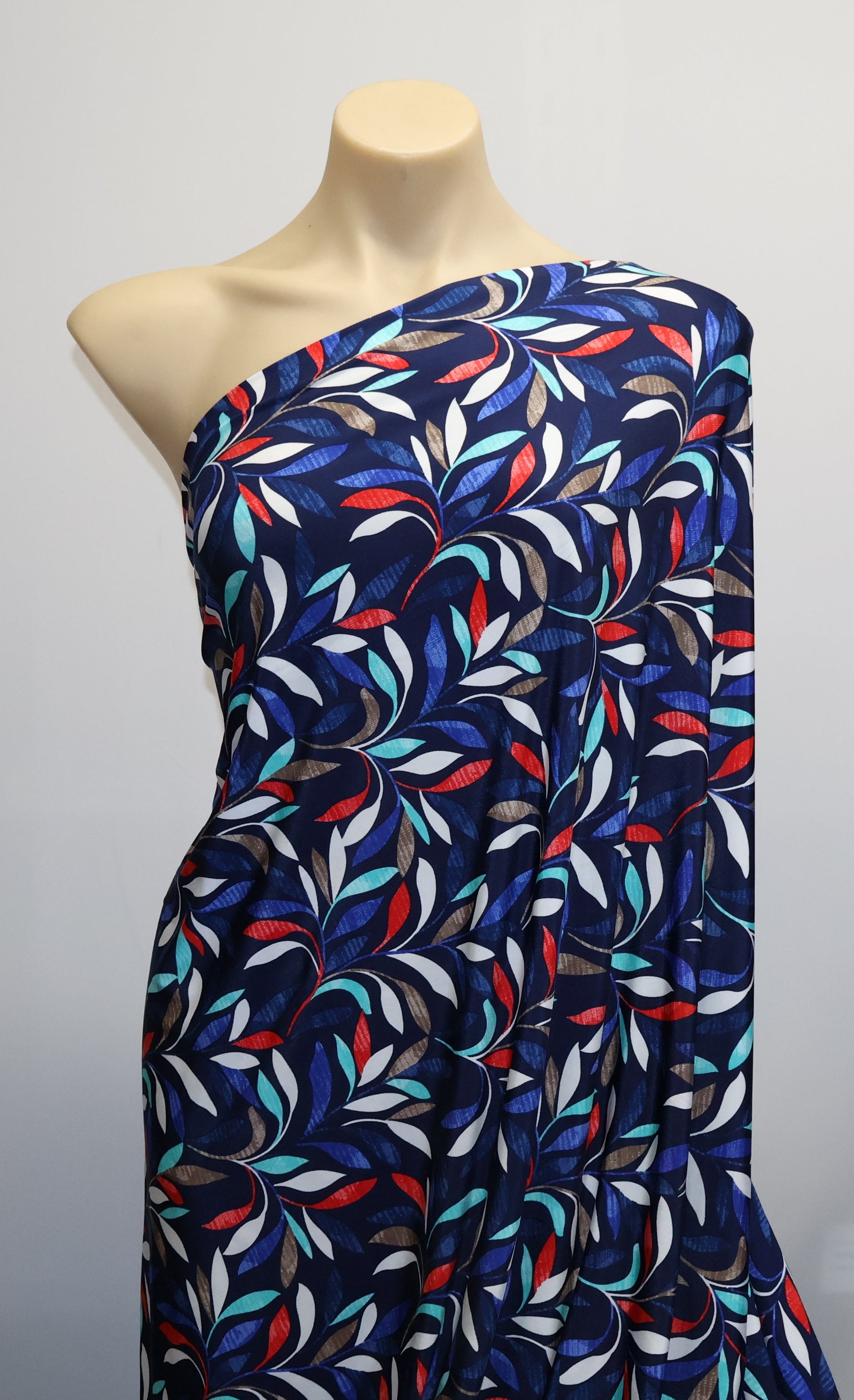 Mannequin wearing a colorful patterned dress against a plain background